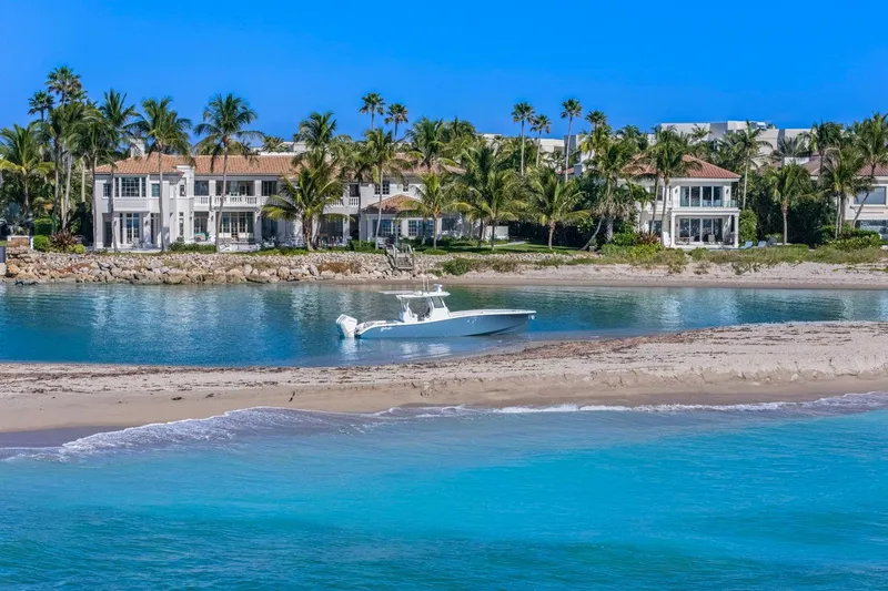 New Stock Yacht Photos Pics 2026 Yellowfin 36 Offshore boat near luxury waterfront homes and palm trees.