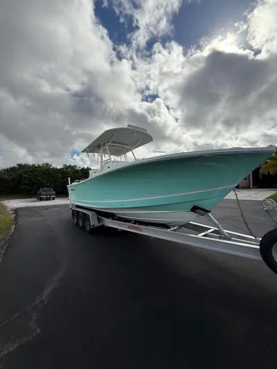Drillin'n Billin Yacht Photos Pics 2017 Regulator 28 boat on trailer under cloudy sky.