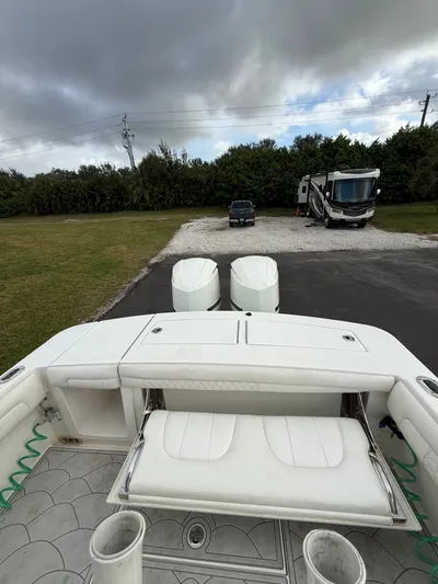 Drillin'n Billin Yacht Photos Pics 2017 Regulator 28 boat with dual engines, parked on asphalt.