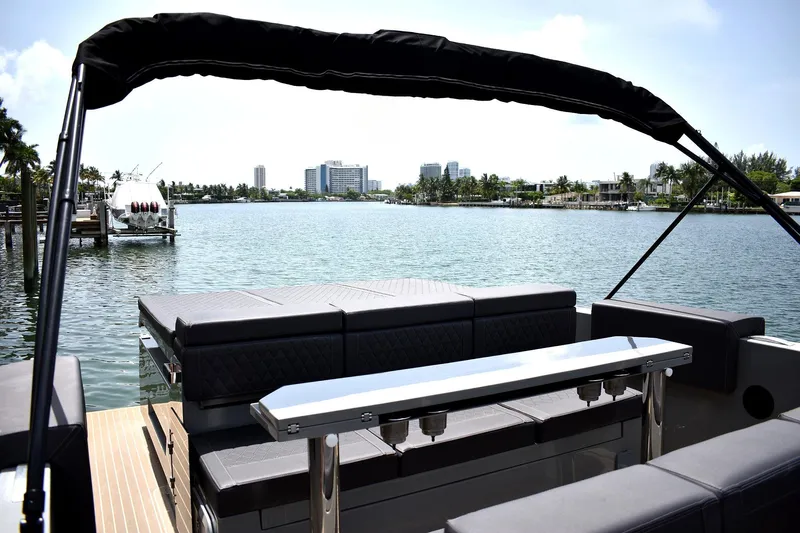  Yacht Photos Pics 2022 De Antonio Yachts D28 Open, luxury seating, scenic waterfront view.