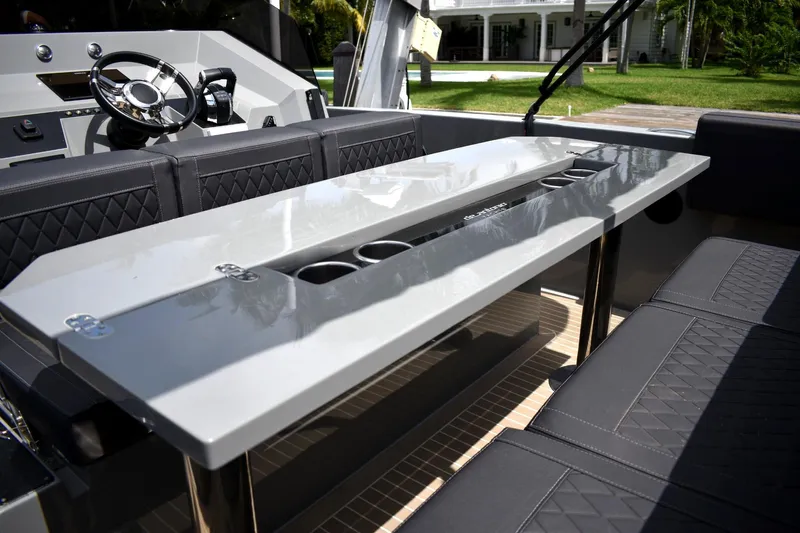  Yacht Photos Pics 2022 De Antonio Yachts D28 Open interior with sleek table and seating.