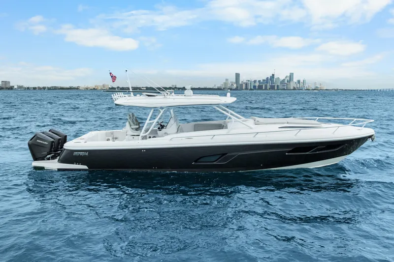 Yacht Photos Pics 2024 Intrepid 41 Valor boat cruising on open water with city skyline backdrop.