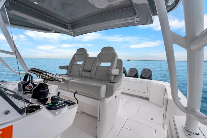  Yacht Photos Pics 2024 Intrepid 41 Valor boat interior with helm and seating, on calm ocean waters.