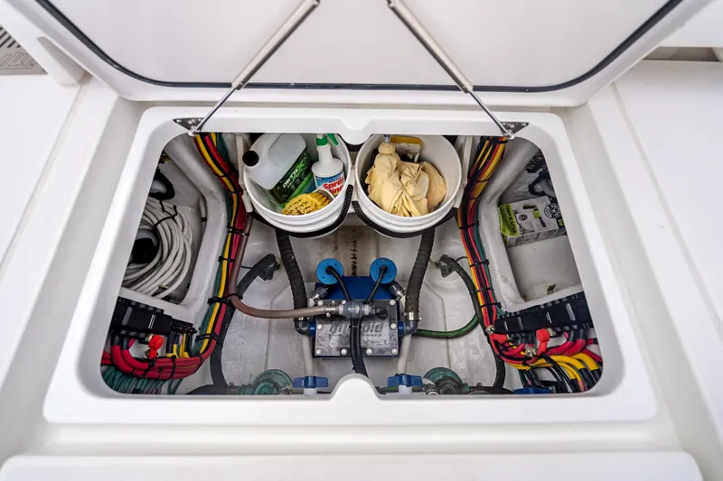  Yacht Photos Pics 2024 Intrepid 41 Valor boat storage compartment with cleaning supplies and wiring.