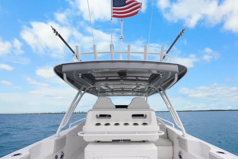  Yacht Photos Pics 2024 Intrepid 41 Valor boat with American flag, open sea, and clear sky.