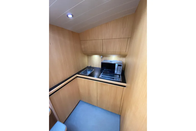  Yacht Photos Pics Compact wooden kitchenette with sink and microwave in a 2008 Teorema 42 ROSSOCORSA.