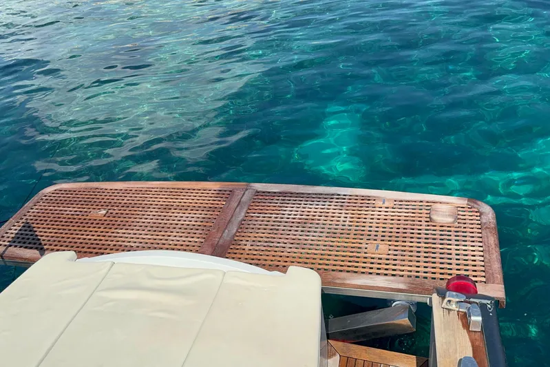  Yacht Photos Pics Teak swim platform on 2008 Custom Teorema 42 ROSSOCORSA yacht, above clear blue water.