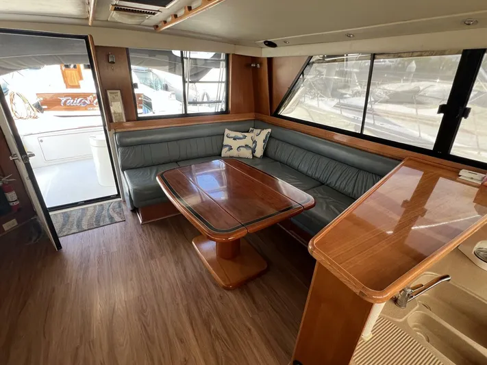 Yacht Z Yacht Photos Pics Interior of 1998 Riviera 48 Convertible yacht with wooden table and leather seating.