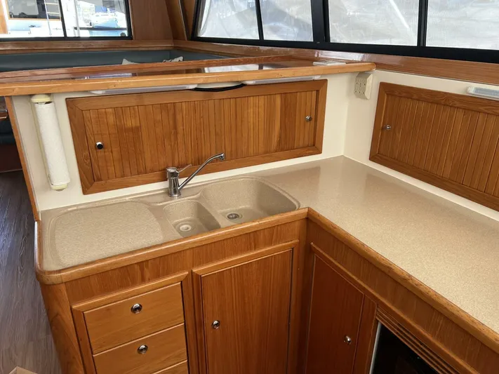 Yacht Z Yacht Photos Pics 1998 Riviera 48 Convertible yacht kitchen with wooden cabinets and dual sink.