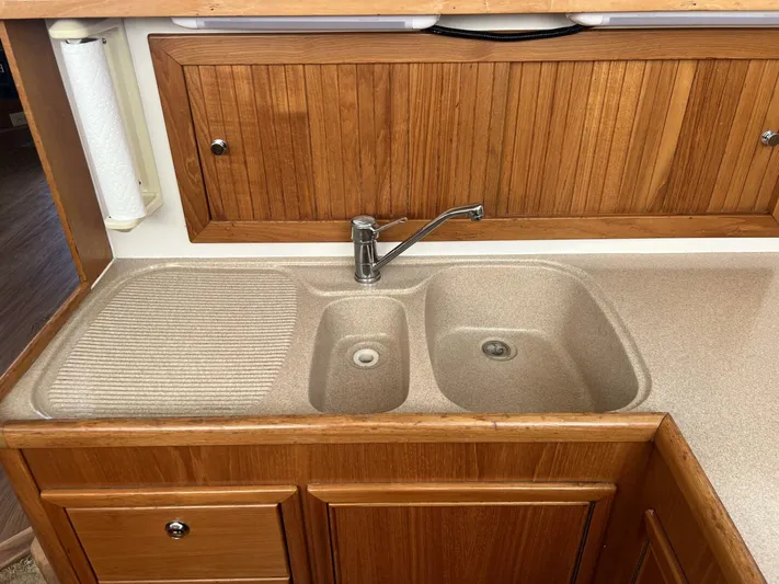 Yacht Z Yacht Photos Pics Kitchen sink area in a 1998 Riviera 48 Convertible boat, featuring wooden cabinetry.