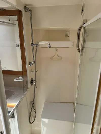 Yacht Z Yacht Photos Pics Shower area in 1998 Riviera 48 Convertible yacht, featuring a handheld showerhead and glass door.