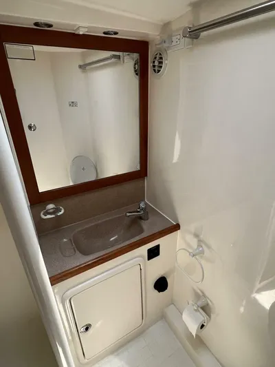 Yacht Z Yacht Photos Pics Bathroom interior of 1998 Riviera 48 Convertible yacht, featuring sink, mirror, and toilet.