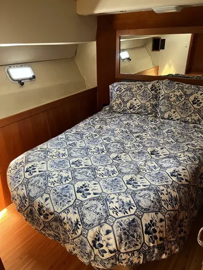 Yacht Z Yacht Photos Pics Cozy bedroom in 1998 Riviera 48 Convertible yacht with patterned bedding and wooden accents.