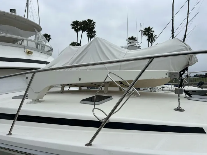 Yacht Z Yacht Photos Pics 1998 Riviera 48 Convertible yacht deck with covered equipment, palm trees in background.