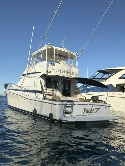 Yacht Z Yacht Photos Pics 1998 Riviera 48 Convertible yacht on calm water, clear sky background.