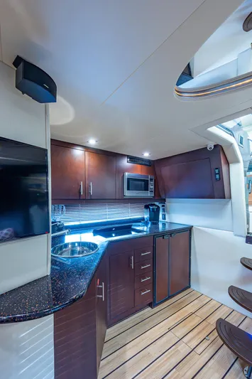 R&r III Yacht Photos Pics 2015 Regal 46 Sport Coupe yacht kitchen with modern appliances and wooden cabinetry.