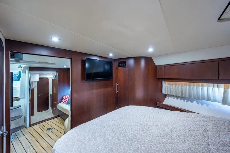 R&r III Yacht Photos Pics Luxurious bedroom interior of 2015 Regal 46 Sport Coupe yacht with TV and wood paneling.
