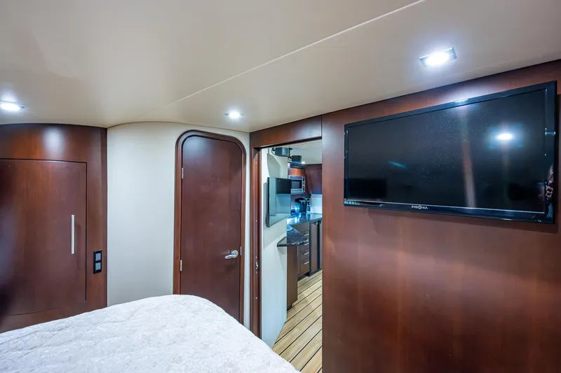 R&r III Yacht Photos Pics Interior of 2015 Regal 46 Sport Coupe with TV, bed, and wooden cabinetry.