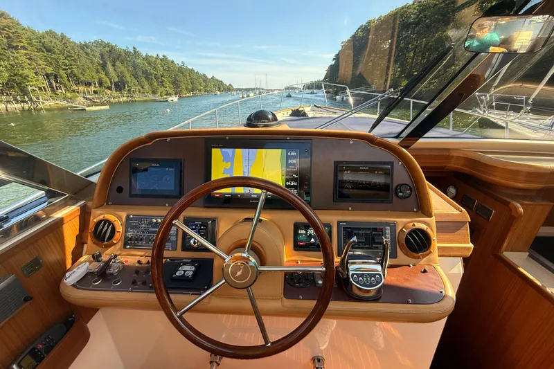 Mamma Mia Yacht Photos Pics Helm of 2006 Mochi Craft 51 Dolphin yacht with navigation equipment and scenic waterway view.