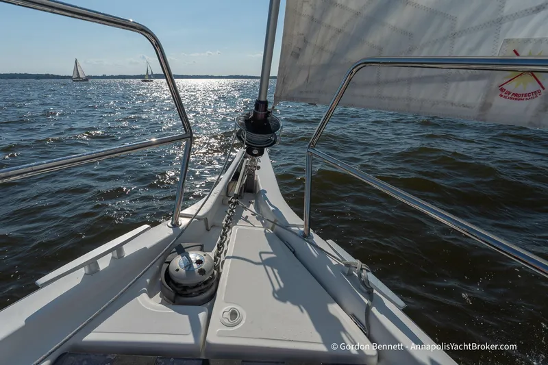 No Regrets Yacht Photos Pics 2019 Jeanneau Sun Odyssey 440 sailing on open water, with glistening waves and distant sailboats.