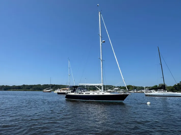 Basia Yacht Photos Pics Sailboat on calm water, 1987 Sabre 42, under clear blue sky.