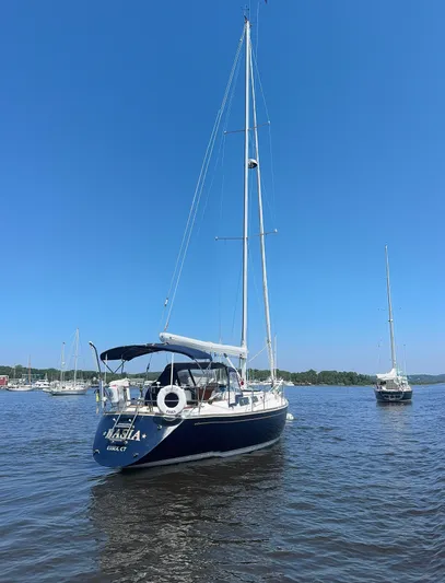 Basia Yacht Photos Pics 1987 Sabre 42 sailboat on calm water under clear blue sky.