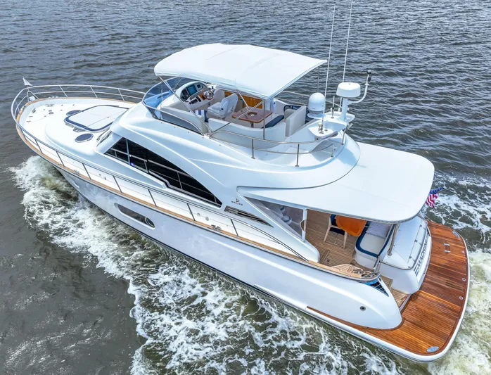 Madrine Yacht Photos Pics 2015 Riviera 54 Belize Daybridge yacht cruising on open water, showcasing sleek design and luxury.