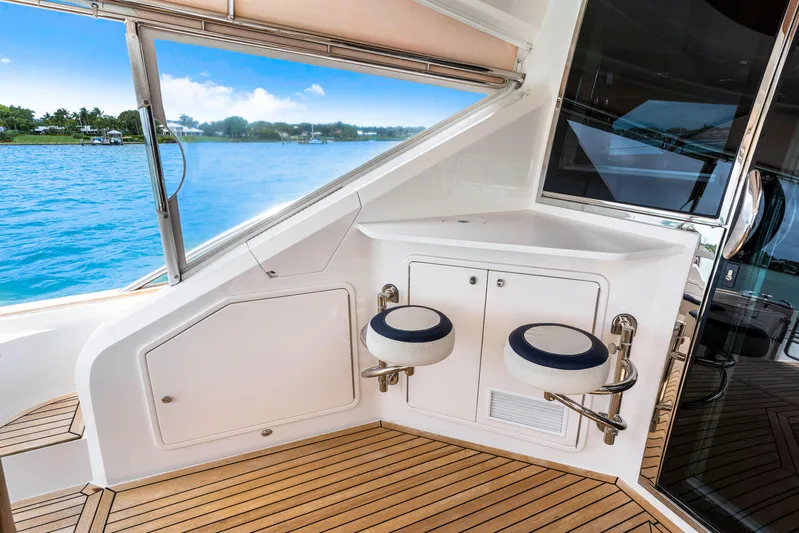 Madrine Yacht Photos Pics 2015 Riviera 54 Belize Daybridge yacht interior with wooden deck and seating by the water.