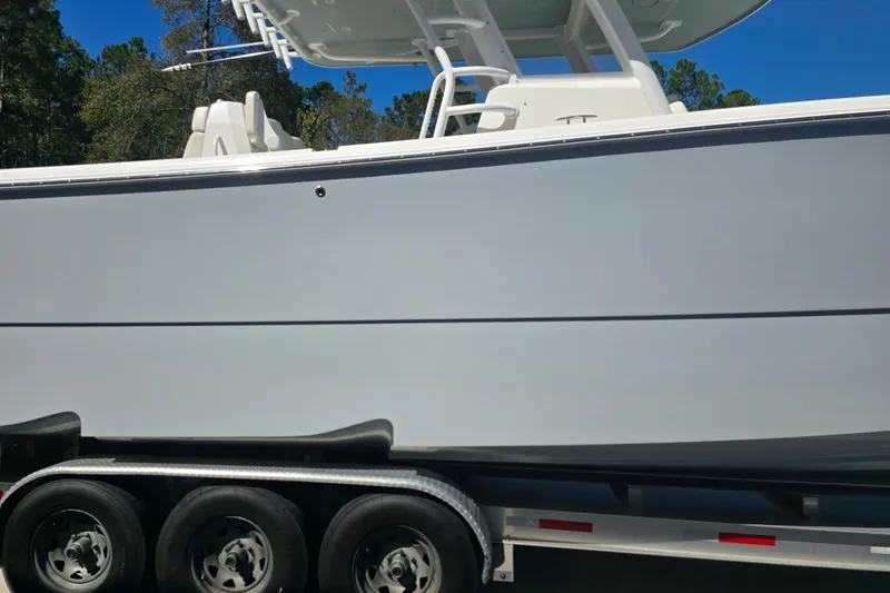 Humble Beginnings Yacht Photos Pics 2022 Invincible 33 Catamaran on trailer, side view under clear blue sky.