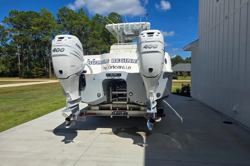 Humble Beginnings Yacht Photos Pics 2022 Invincible 33 Catamaran with twin 400 Verado engines, parked on a driveway.