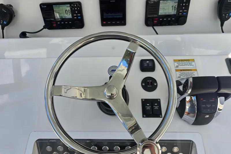 Humble Beginnings Yacht Photos Pics Steering wheel and controls of 2022 Invincible 33 Catamaran boat cockpit.