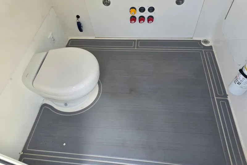 Humble Beginnings Yacht Photos Pics 2022 Invincible 33 Catamaran interior with toilet and control panel.