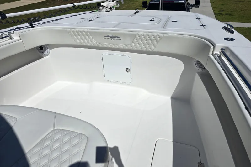 Humble Beginnings Yacht Photos Pics 2022 Invincible 33 Catamaran interior with white seating and storage compartments.