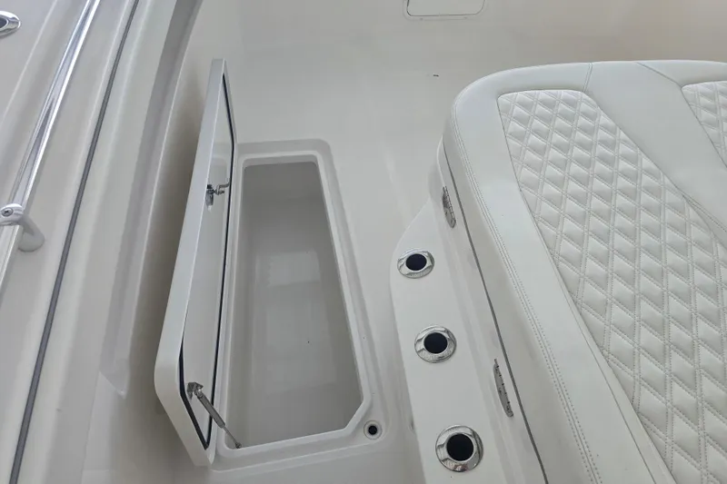 Humble Beginnings Yacht Photos Pics 2022 Invincible 33 Catamaran interior with open storage compartment and quilted seating.