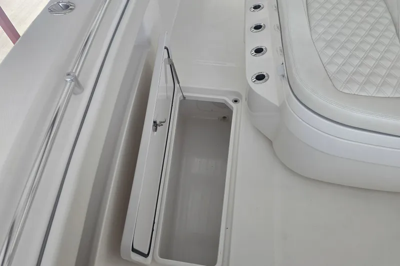 Humble Beginnings Yacht Photos Pics 2022 Invincible 33 Catamaran interior with open storage compartment and cushioned seating.