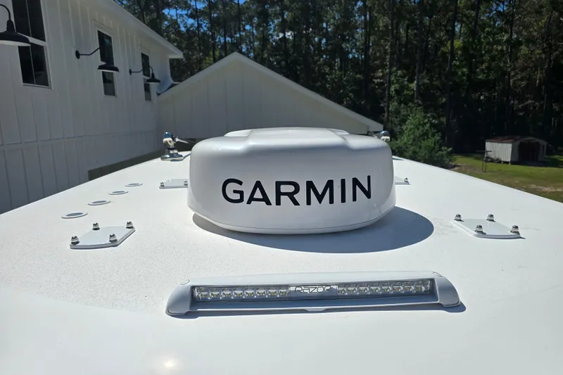 Humble Beginnings Yacht Photos Pics Garmin radar on 2022 Invincible 33 Catamaran, with white building and trees in background.