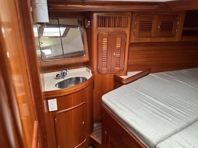 Last Love Yacht Photos Pics Luxurious 2014 Passport 545 Vista yacht interior with wood finish, sink, and bed.