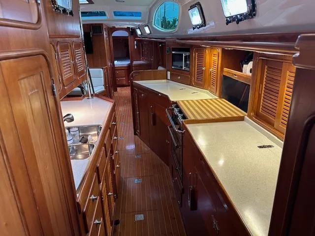 Last Love Yacht Photos Pics Luxurious 2014 Passport 545 Vista yacht interior with wooden cabinetry and modern kitchen amenities.