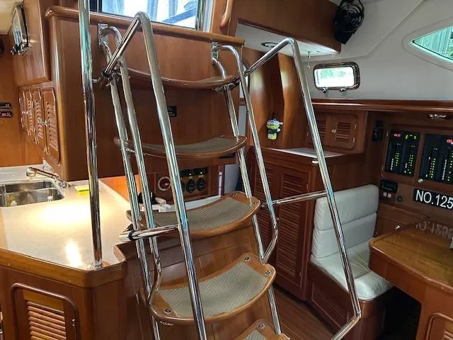 Last Love Yacht Photos Pics Interior of 2014 Passport 545 Vista yacht with wooden cabinetry and metal staircase.
