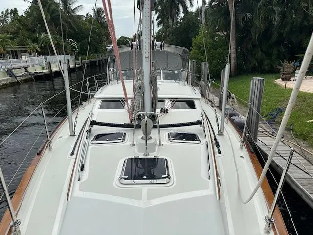 Last Love Yacht Photos Pics Sailboat docked by a canal, Passport 545 Vista, 2014 model, surrounded by lush greenery.