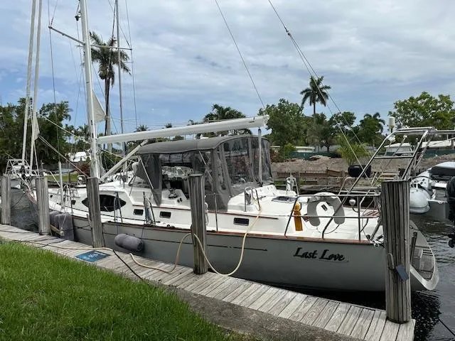 Last Love Yacht Photos Pics Sailboat docked at marina, Passport 545 Vista 2014, named "Last Love," with palm trees in background.