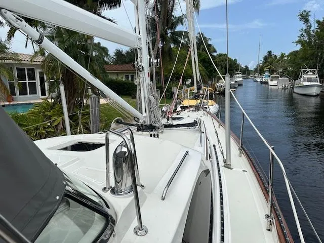 Last Love Yacht Photos Pics Sailboat docked in a canal, surrounded by tropical greenery, Passport 545 Vista, 2014 model.