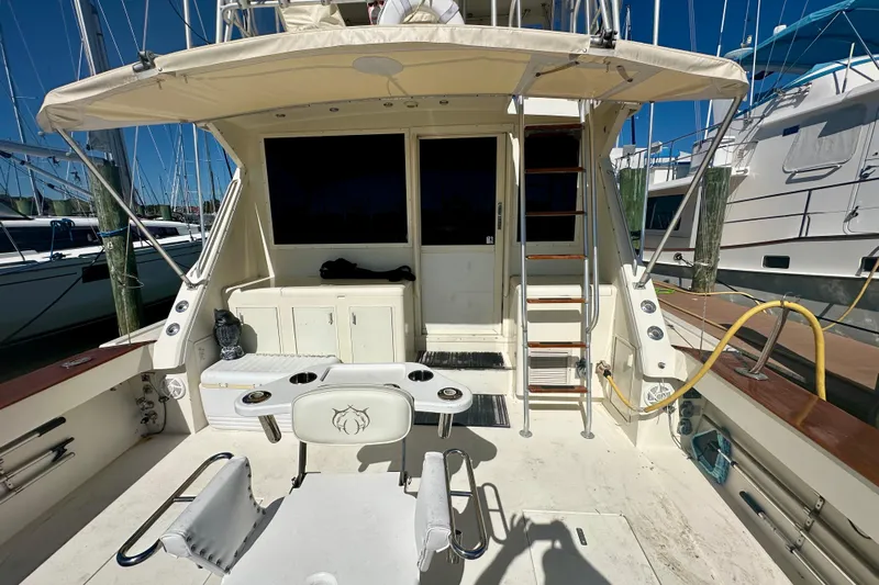  Yacht Photos Pics 1989 Viking 48 yacht deck with seating, ladder, and canopy in a marina setting.