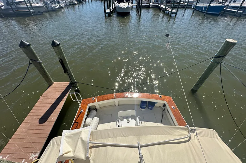  Yacht Photos Pics 1989 Viking 48 boat docked at marina, sun reflecting on water.