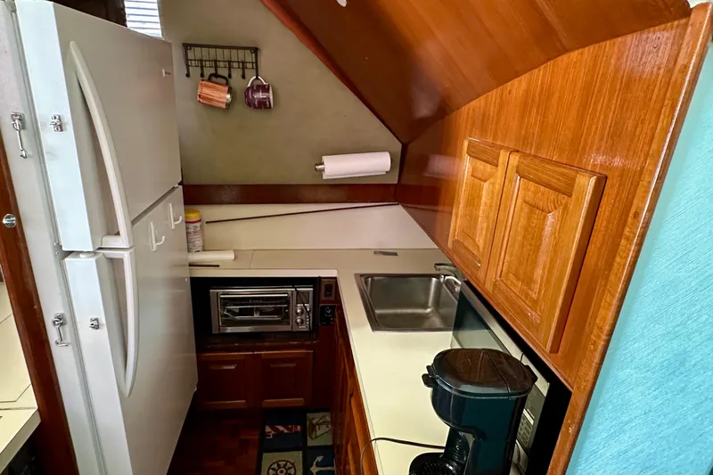 Yacht Photos Pics Compact kitchen in a 1989 Viking 48 yacht with wood cabinetry and modern appliances.