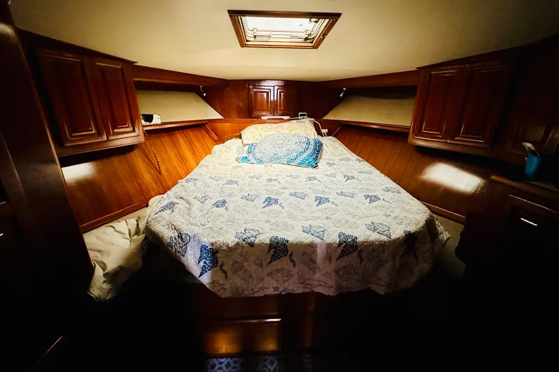  Yacht Photos Pics Cozy cabin bedroom in 1989 Viking 48 yacht with wooden cabinets and patterned bedding.