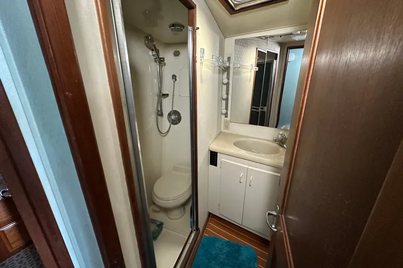  Yacht Photos Pics Compact bathroom in a 1989 Viking 48 yacht with shower, sink, and toilet.