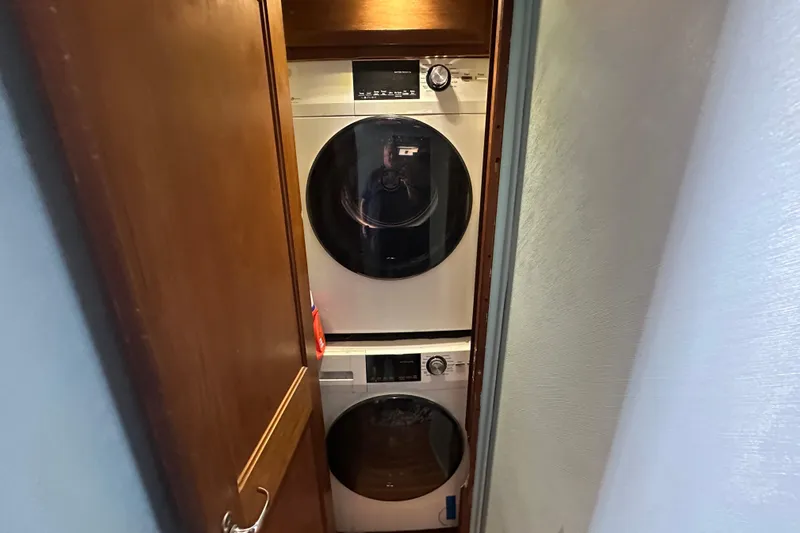  Yacht Photos Pics Stacked washer and dryer in a compact wooden closet, Viking 48, 1989 model.