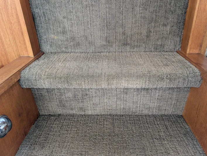 Infinity Bound Yacht Photos Pics Carpeted stairs inside 1991 Carver 430 Cockpit Motor Yacht with wooden trim.