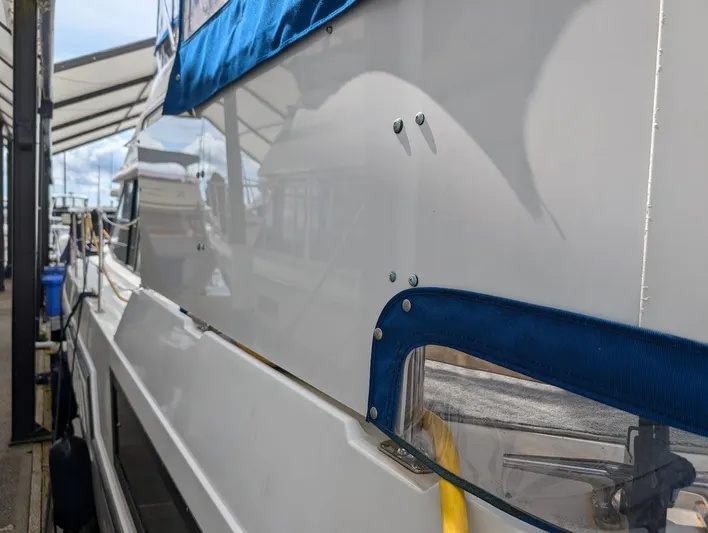 Infinity Bound Yacht Photos Pics 1991 Carver 430 Cockpit Motor Yacht docked, featuring blue canvas and sleek white exterior.